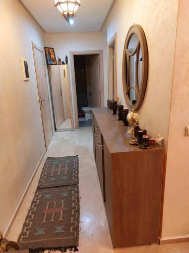 ein Badezimmer mit einem Waschtisch mit einem Spiegel und einem Waschbecken in der Unterkunft Bouskoura, Joli appartement coup de cœur in Bouskoura