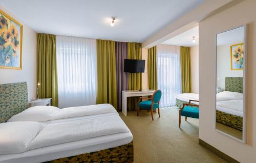 a hotel room with two beds and a desk at ALPHA HOTEL Hermann von Salza in Bad Langensalza