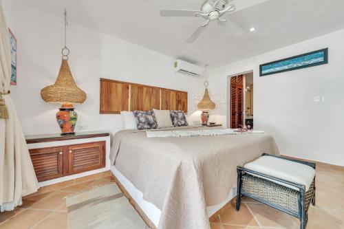 a bedroom with a bed and a table and a fan at Casa Vista al Mar Isla Mujeres in Isla Mujeres