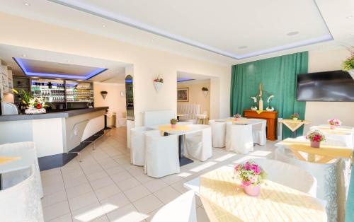 a restaurant with white tables and white chairs at ALPHA HOTEL Hermann von Salza in Bad Langensalza