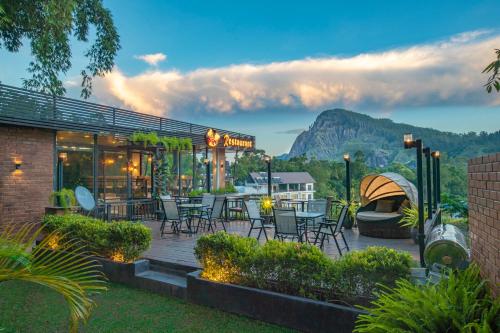 a patio with a table and chairs and a grill at Ella Heritage in Ella