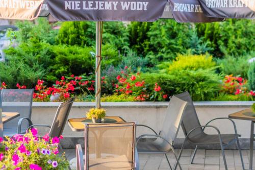 an outdoor cafe with tables and chairs and flowers at Hotel Lantier Wellness & Spa in Bytom