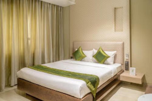 a bedroom with a large bed with green and white pillows at HOTEL PRATIKSHA RESIDENCY in Navi Mumbai