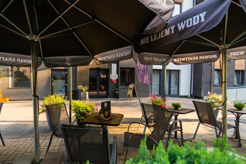 een groep tafels en stoelen met parasols bij Hotel Lantier Bytom - Katowice - Chorzów in Bytom