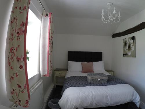 a small bedroom with a bed and a window at Daisy Cottage in Wakefield