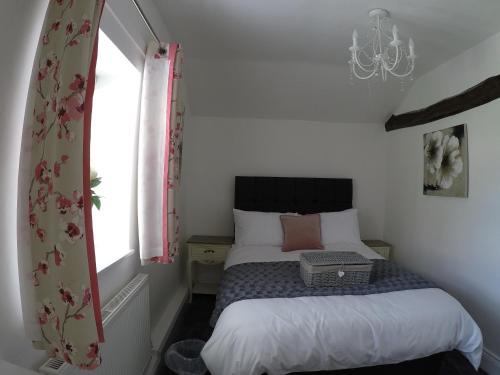 a small bedroom with a bed and a window at Daisy Cottage in Wakefield