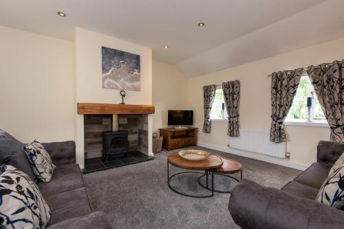 a living room with a couch and a fireplace at East Farm Cottage in Durham