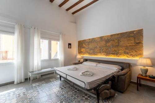 een slaapkamer met een bed en een schilderij aan de muur bij Suite Loft 4 PAX by costablancarent in Denia
