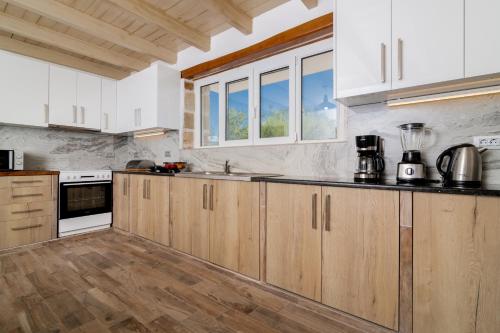 a kitchen with white appliances and wooden cabinets at Villa di Pietra in Lithakia