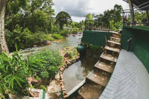 a river with stairs next to a bridge at Dolagawa in Deniyaya