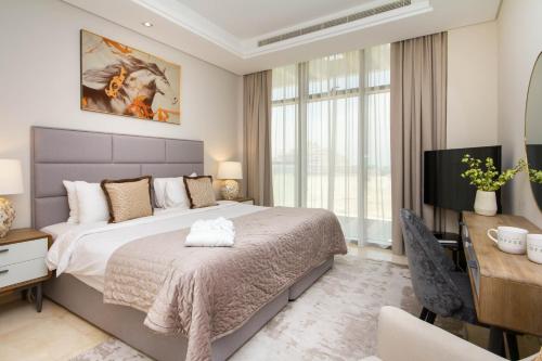 a bedroom with a bed and a desk and a television at Bespoke Holiday Homes - Palm Jumeirah- 2 Bedroom Sea View with Pool & Beach Access, Th8 in Dubai