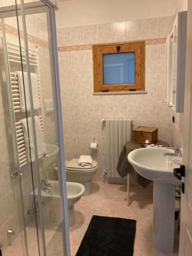 a bathroom with a toilet and a sink and a shower at G&B Apartments in Tignale