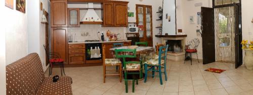 a kitchen with wooden cabinets and a table and chairs at La villa di campagna in Pisticci