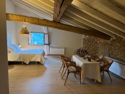 a bedroom with a bed and a table and chairs at Casa Tapiolas Rectoría in Molló