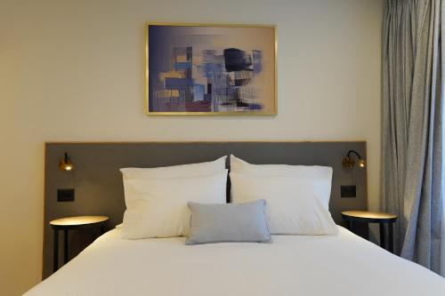 una camera con un letto bianco con due cuscini di Urbanic Apartments a Gerusalemme