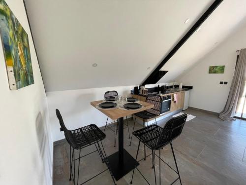 een keuken met een tafel en stoelen in een kamer bij Chalet du Piton Bleu in Le Tampon