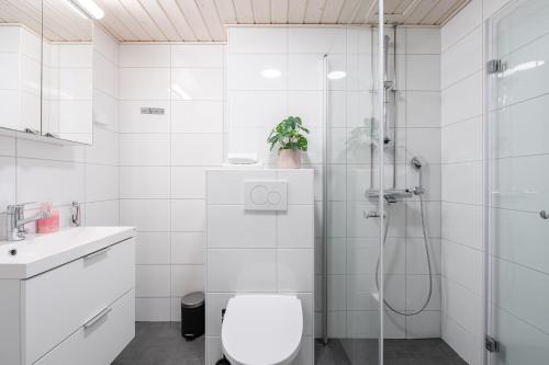 a white bathroom with a toilet and a shower at 2ndhomes Tampere "Tammerinpuisto" Apartment in Tampere