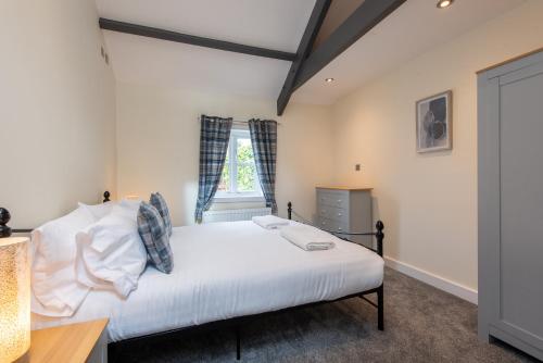 a bedroom with a bed and a window at East Farm Cottage in Durham