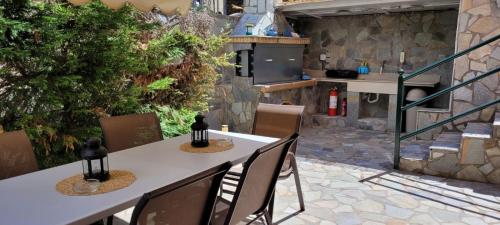 a patio with a table and chairs and a kitchen at cozy apartment nafpaktos in Nafpaktos