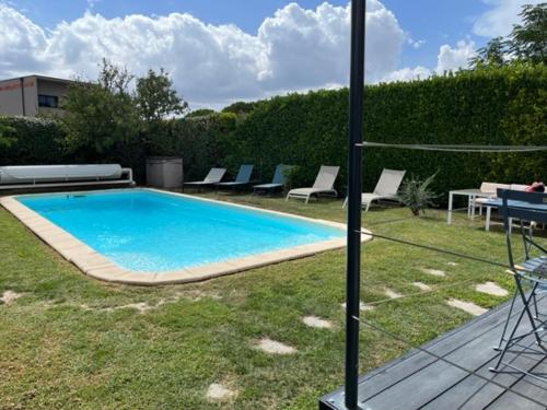 une piscine avec des chaises longues et une table dans l'établissement Chez Frédérique et Jean-Claude, à Les Taillades