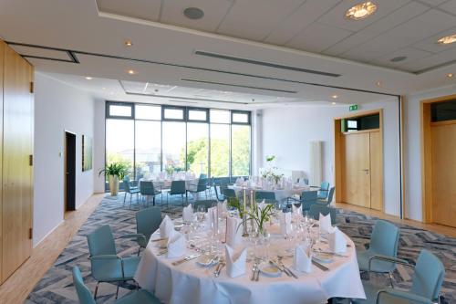a conference room with white tables and chairs at Hotel am Kloster in Werne an der Lippe