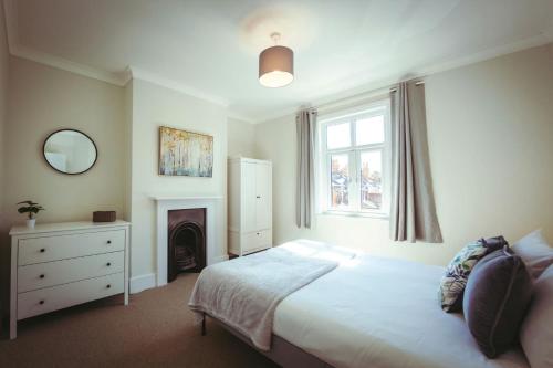 a bedroom with a bed and a fireplace and a window at Vicarage Cottage - Old Town bolthole in Old Town