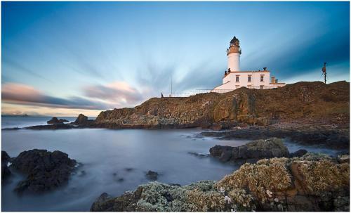 a lighthouse sitting on top of a rocky island at Turnberry accommodation in Turnberry