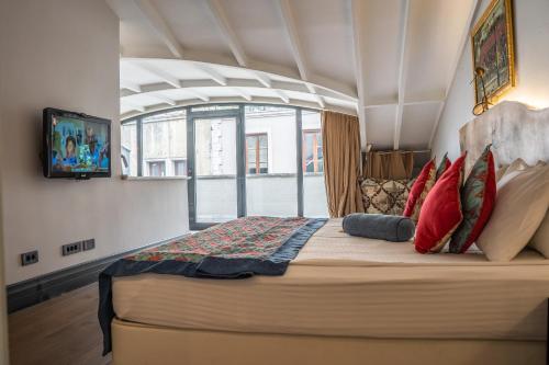 una camera da letto con un grande letto con cuscini rossi di West Pera Hotel a Istanbul