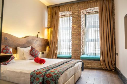 a hotel room with a bed and two windows at West Pera Hotel in Istanbul