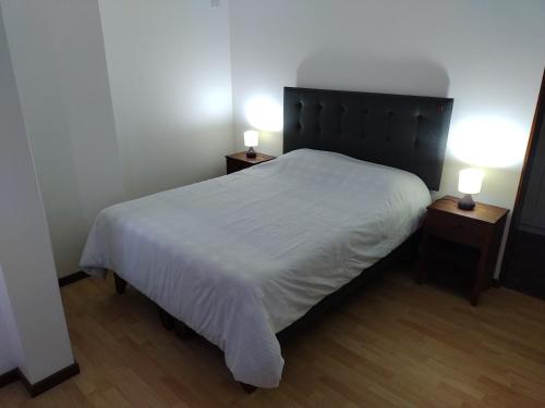 a bedroom with a white bed with two night stands at DepartoCasa1 Premium in Arica