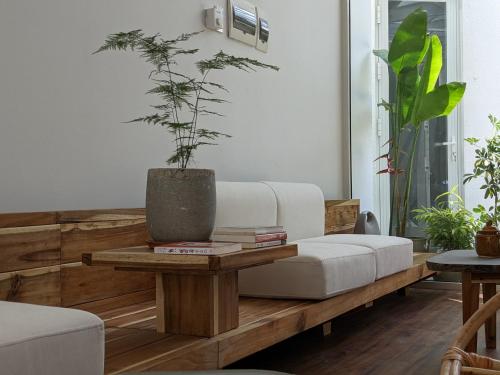 a living room with a couch and a table with a potted plant at Metta Homestay Hue in Hue