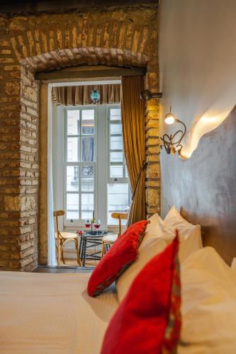 a bed with red pillows in a room with a window at West Pera Hotel in Istanbul