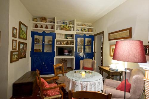 een woonkamer met een tafel en blauwe deuren bij Don Claudio in Grazalema
