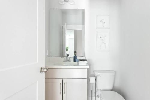 łazienka z umywalką, toaletą i lustrem w obiekcie Trendy Park Circle Townhome w mieście Charleston