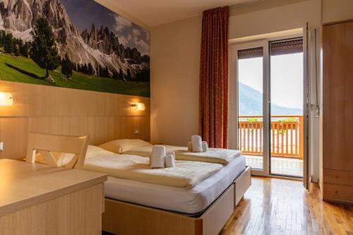 モルヴェーノにあるHotel Lory - Molveno - Dolomitiのベッド2台と大きな窓が備わるホテルルームです。