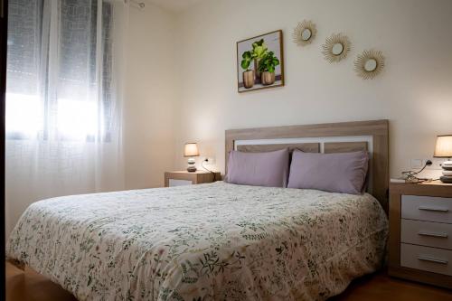 a bedroom with a bed and two lamps and a window at Apartamento Timple in Icod de los Vinos