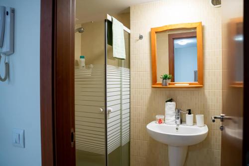 a bathroom with a sink and a shower with a mirror at Apartamento Timple in Icod de los Vinos