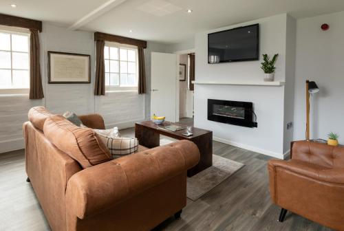 a living room with two couches and a fireplace at Stableside at York Racecourse in York