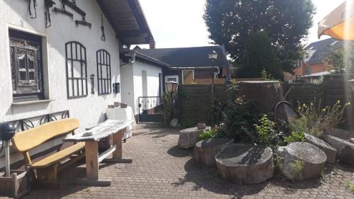 a patio with a bench and some logs at Pension Alte Schmiede in Greifswald