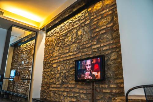 a wall with a tv on a stone wall at West Pera Hotel in Istanbul