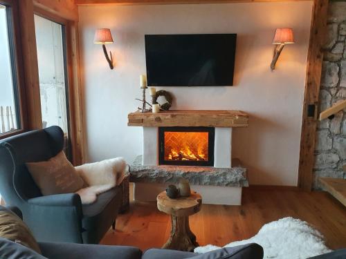 a living room with a fireplace and a tv at Bichlhof in Kaisers