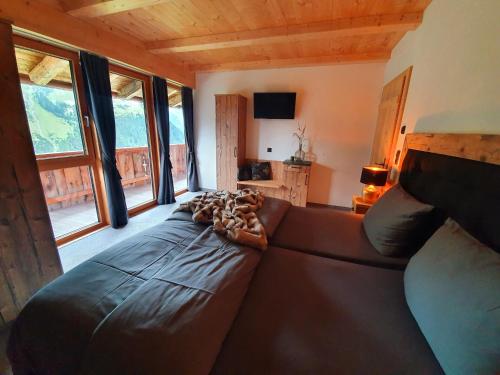 a large leather couch in a living room with windows at Bichlhof in Kaisers