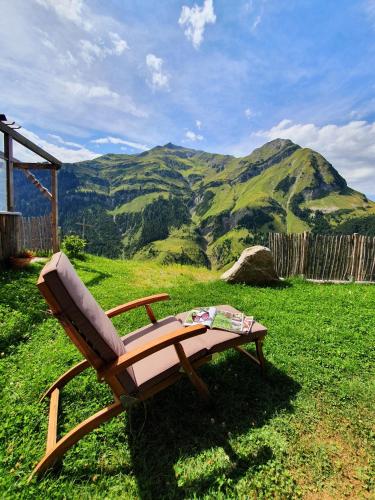 a chair sitting in the grass with a view of mountains at Bichlhof in Kaisers