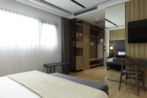 a bedroom with a bed and a tv and a bedroom at Hotel Uji Ftohte Tepelene in Tepelenë