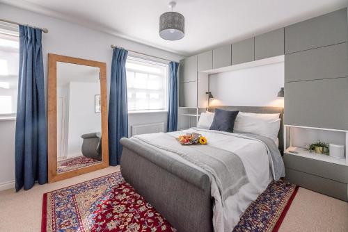 a bedroom with a large bed and a mirror at Martlet Cottage Aldeburgh Air Manage Suffolk in Aldeburgh