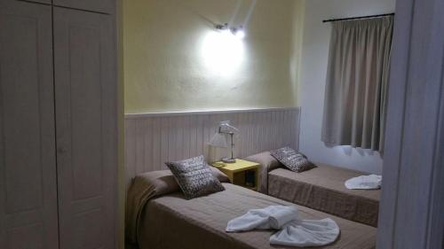 a hotel room with two beds and a lamp at Apartamentos Timon - Emar Hotels in Es Pujols
