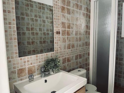 a bathroom with a sink and a mirror and a toilet at Ocean view apartment in Santiago del Teide