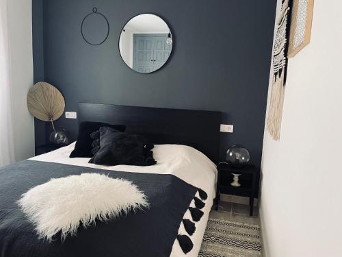 a bedroom with a black and white bed with a mirror at Ocean view apartment in Santiago del Teide
