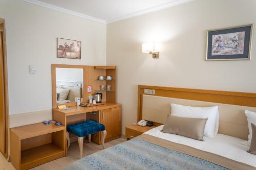 a bedroom with a bed and a desk and a mirror at Patalya Lakeside Resort Hotel in Golbası