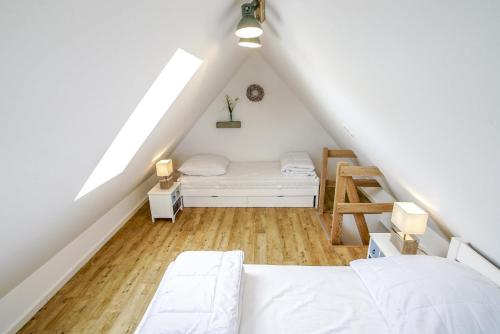 a attic bedroom with a bed and a ladder at Ferienhaus 16 "Gut Tossens" in Tossenserdeich